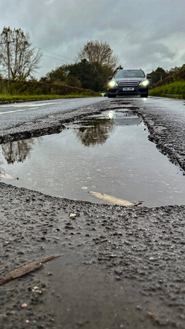 Car driving on a road that has potholes